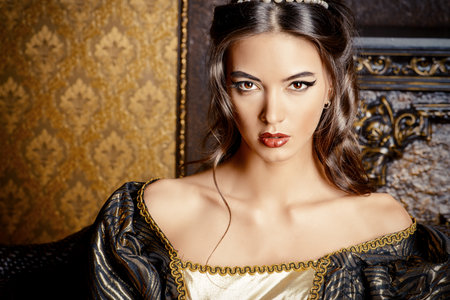 Renaissance Style -  beautiful young woman in the lush expensive dress in an old palace interior. Vintage style. Fashion.の写真素材
