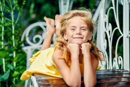 Happy smiling girl resting in a beautiful summer park. Happy childhood. Holidays.の写真素材