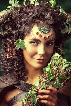 Fabulous Faun blowing the horn of plenty. Fantasy. Body painting.の写真素材