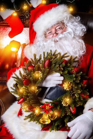 Santa Claus sitting at home with gifts, dressed in his home clothesの写真素材