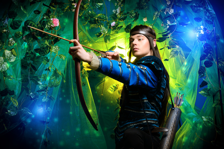 Portrait of a male elf with a bow and arrows in a magical forest.の写真素材