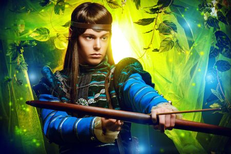 Portrait of a male elf with a bow and arrows in a magical forest.の写真素材