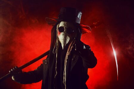 Portrait of a terrible plague doctor with a scytheの写真素材