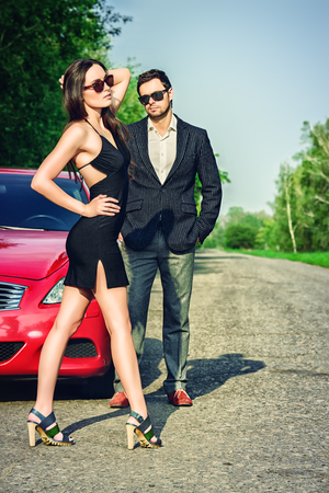 Glamorous couple near the car. Beauty, fashion. Love concept.の写真素材