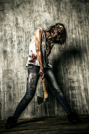 Scary bloody zombie girl with an ax. Halloween.の写真素材