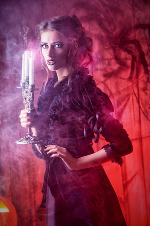 Beautiful girl in medieval dress in a mysterious abandoned houseの写真素材