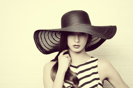 Portrait of a beautiful graceful woman in elegant hat with a wide brimの写真素材