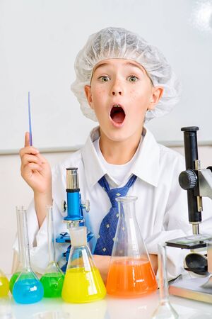 A boy is studying in the laboratory. He is shocked and surprisedの写真素材