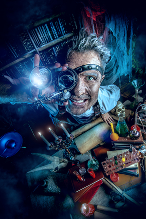 Portrait of a crazy medieval scientist working in his laboratory. Alchemist. Halloween.の写真素材
