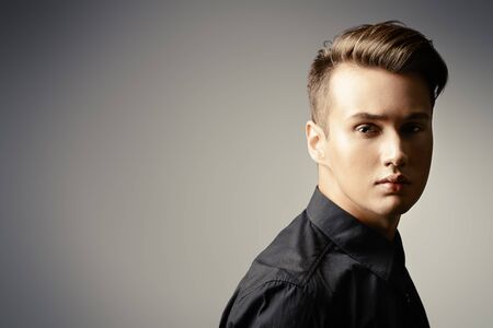 Close-up portrait of a handsome young man thoughtfully looking at the camera.の写真素材