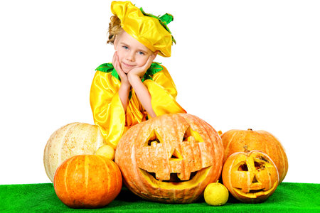 Pretty little girl in a costume of pumpkin posing with pumpkins.の写真素材