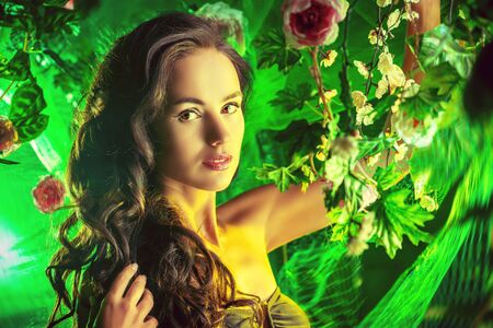 Beautiful brunette woman in bikini among tropical plants.の写真素材