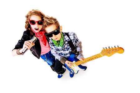 Modern teenagers playing electric guitar and sing on a stage with expression. Isolated over white.の写真素材