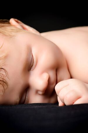 Little newborn baby asleep. Black background.の写真素材