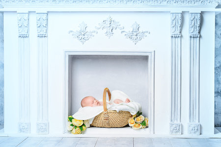 Beautiful newborn baby sleeping peacefully on a white fireplace.の写真素材