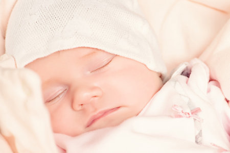 Sweet little newborn baby sleeping in her bed.の写真素材