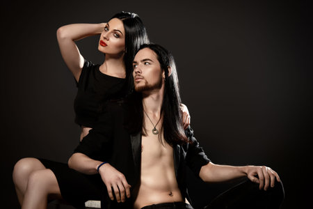 Beautiful gorgeous couple in elegant evening dresses. Fashion, glamour. Black background.の写真素材