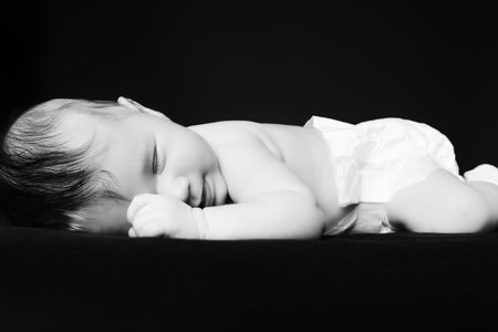 Little newborn baby asleep. Black background.の写真素材