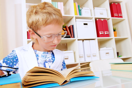 Smart boy absorbed in reading a book. Education.