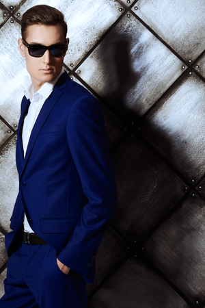 Fashion shot of a handsome young man in elegant classic suit and sunglasses.の写真素材