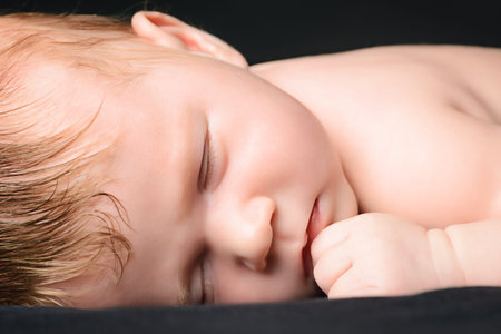 Little newborn baby asleep. Black background.