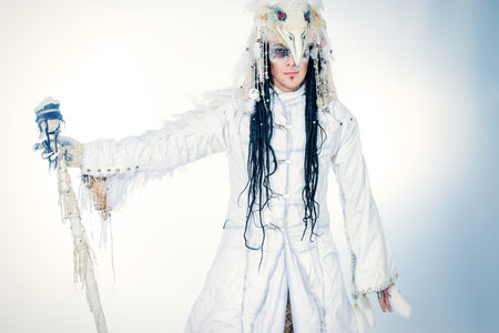Artistic handsome man in a scenic suit of white raven. Ethnic costume. Isolated over white.