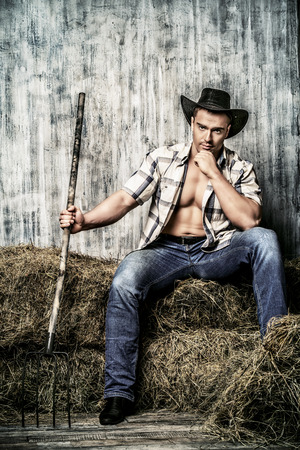 Sexy cowboy on a haystack. Western style.の写真素材