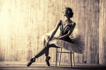 Professional ballet dancer posing at studio over grunge background. Art concept. Toned photo, vintage style.の写真素材