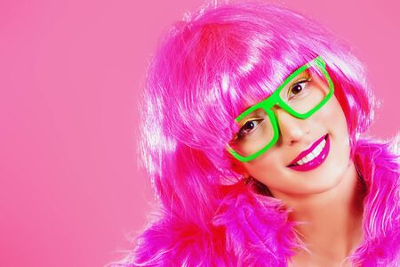 Charming fashion model alluring in sexy colourful clothes. Bright fashion. Pin-up, pink style. Optics, eyewear. Studio shot.の写真素材