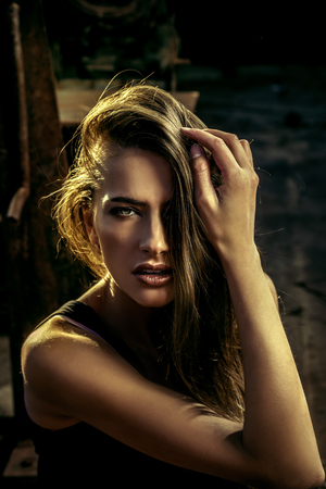 Close-up portrait of a sensual woman with beautiful hair posing over urban background. Fashion shot.の写真素材