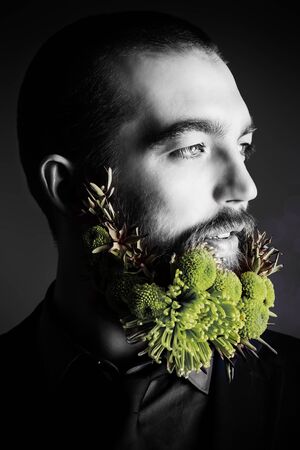 Profile of a handsome man with a beard of green flowers. Men's beauty. Barbershop.の写真素材