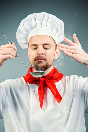 Chef tries cooked dish. Occupation. Studio shot.の写真素材