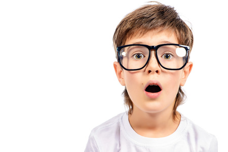 Surprised smart boy in big glasses staring at the camera. Education. Studio shot. Isolated over white.の写真素材