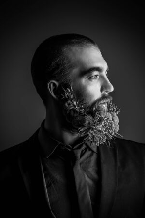Profile of a handsome man with a beard of green flowers. Men's beauty. Barbershop.の写真素材