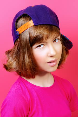 Portrait of a smiling teen girl over pink background.の写真素材