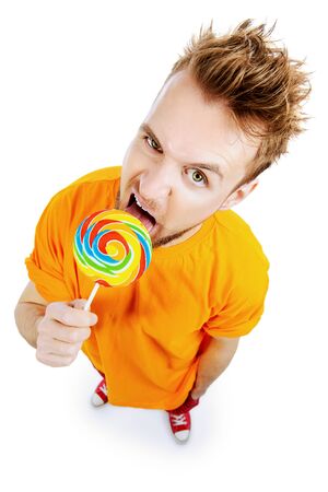 Funny young man licking lollipop. Isolated over white.の写真素材