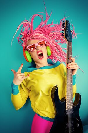 Female rock star playing the electric guitar. Bright style. Show business.の写真素材