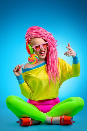 Trendy glamorous girl eating lollipop. Bright style.の写真素材