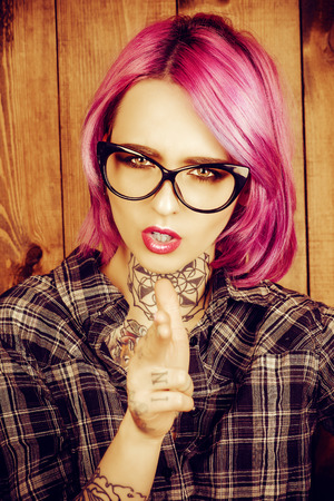 Cool girl with bright crimson hair and tattoo on her body. Modern generation. Optics style.の写真素材