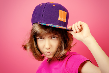 Portrait of a serious teen girl over pink background.の写真素材