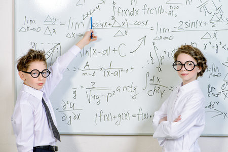 Two students standing by the school board in the laboratory.