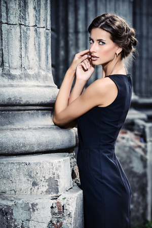 Vogue model wearing black dress posing over urban background. Fashion shot.の写真素材