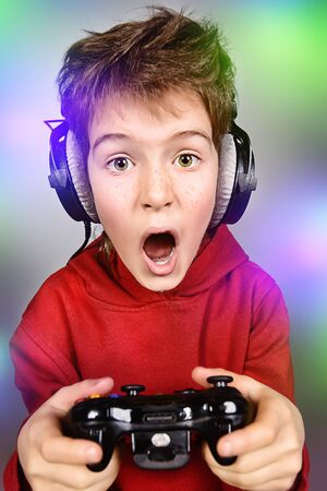 Funny boy gamer with a controller and headphones. Studio shot.の写真素材