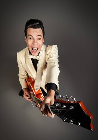 Imposing male musician  plays and sing in the style of the sixties. Rock'n'roll, jazz man. Beat generation.の写真素材