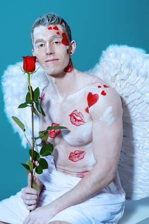 Inspired, romantic man-angel with red rose. Valentine's day. Love concept.