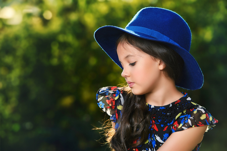 Happy eight year girl outdoor on a bright sunny day. Summer holidays. Kid's fashion.の写真素材