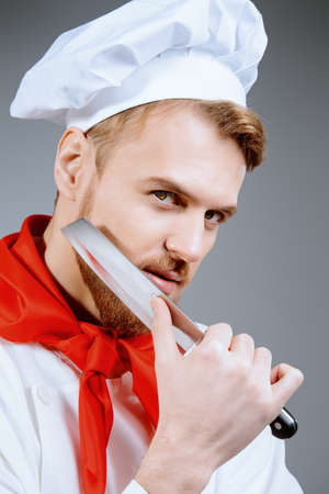 Portrait of a professional male cook holding a knife. Occupation. Studio shot.の写真素材