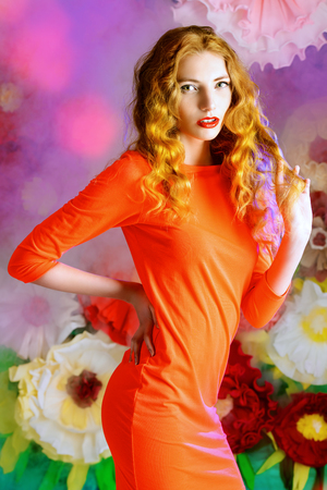 Fashion shot of a beautiful model posing on a background of bright large flowers. Beauty, fashion. Summer inspiration.の写真素材