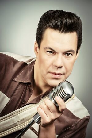 Handsome male singer, who plays in the style of the sixties. Rock'n'roll, jazz man. Nostalgia.の写真素材