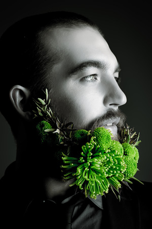 Profile of a handsome man with a beard of green flowers. Men's beauty. Barbershop.の写真素材